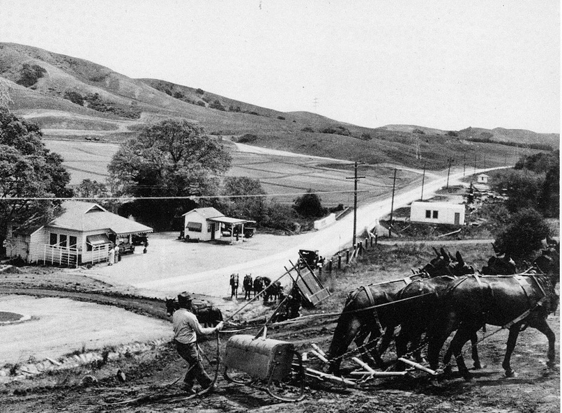 Mule-drawn "Fresno Grader" working near Marshall store and gas station on Orinda Way. The first Orinda fire house is on the right.