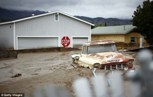 A truck and garage buried in mud after flooding in Highland (1969).